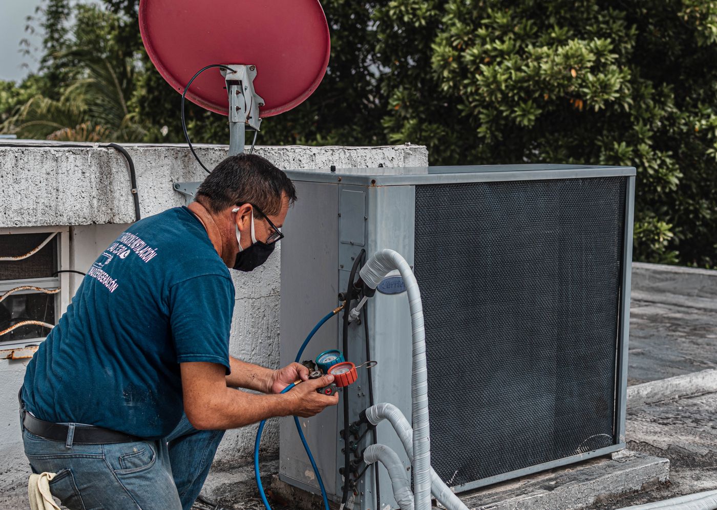 Technician checking an air conditioning unit as part of a system inspection